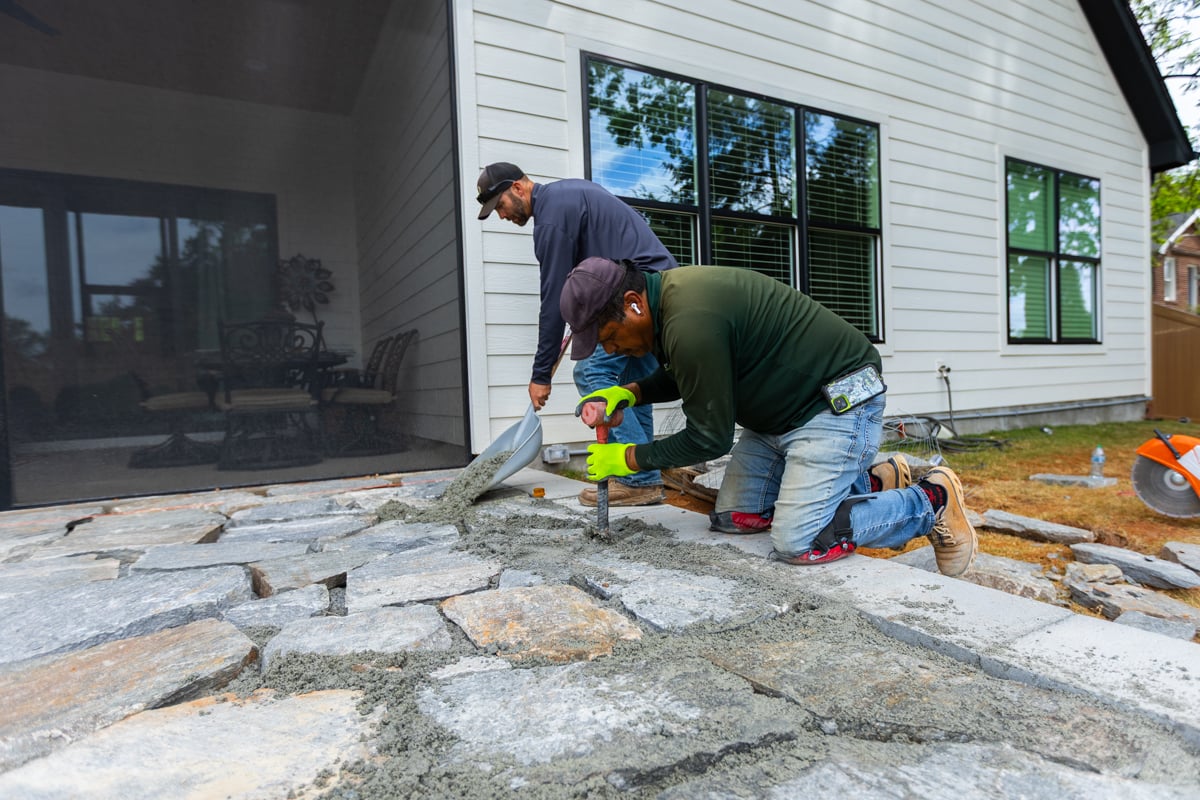 landscape design crew constructing a stone patio