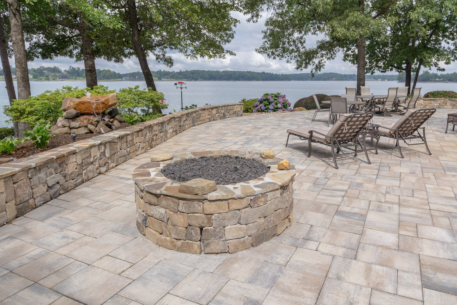 fire pit and seating area on a lakefront landscape