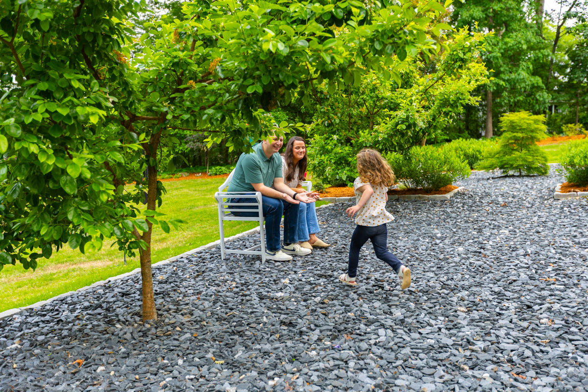 family kids gravel patio backyard bench seat trees shrubs