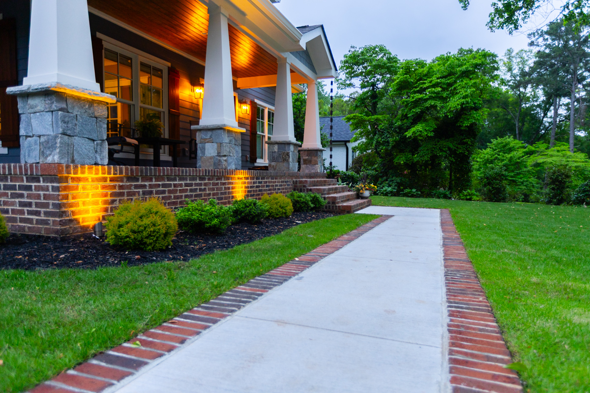 nice landscape lighting wash planting bed mulch shrubs concrete brick accent front entry 2