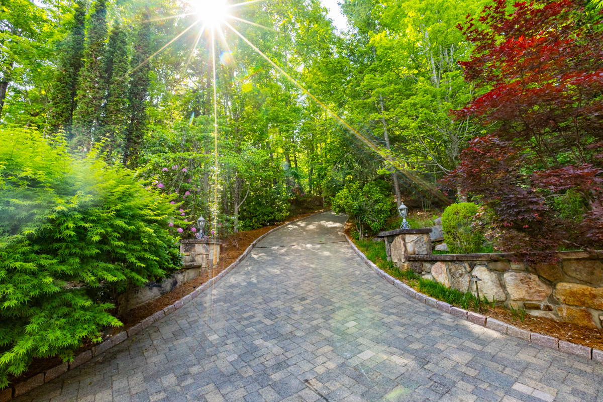 nice paver driveway stone wall landscape light trees