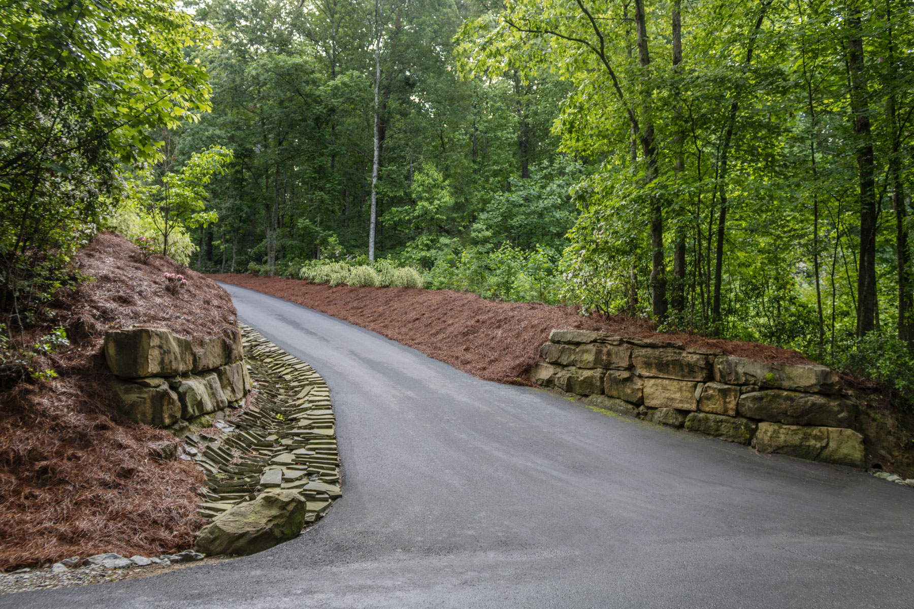 nice driveway dry creek stone boulder wall mulch pine needle fines