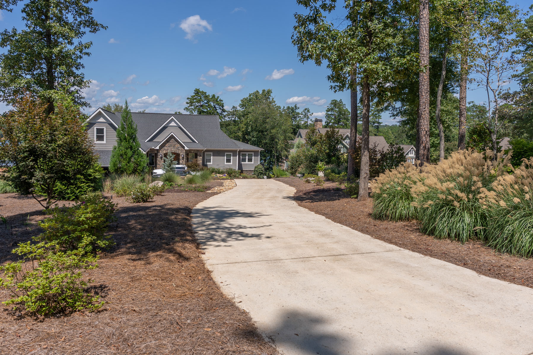 nice driveway entrance home grasses trees shrubs mulch