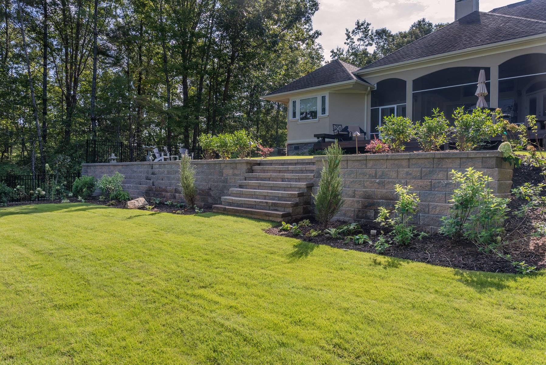 nice stone retaining wall planting bed grass steps