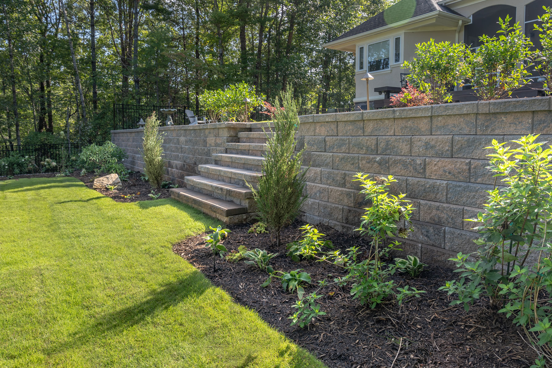 stone retaining wall planting bed grass steps